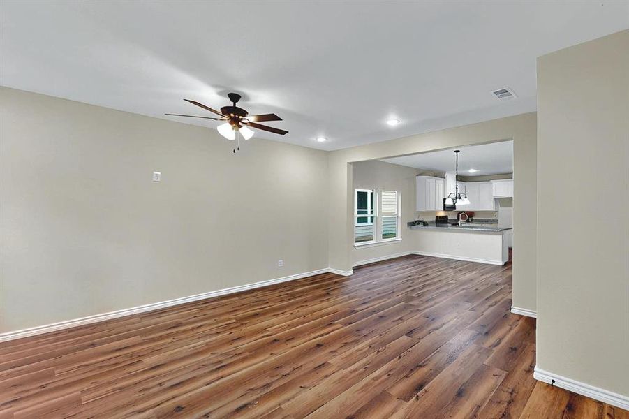 Unfurnished living room featuring visible vents, a ceiling fan, wood finished floors, and recessed lighting Unfurnished living room featuring visible vents, a ceiling fan, wood finished floors, and recessed lighting
