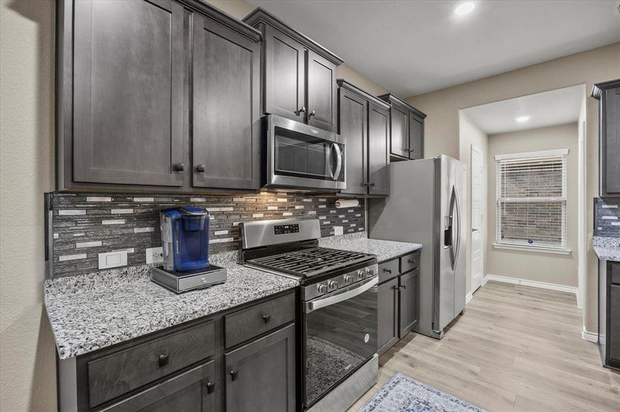 Upgraded backsplash, hardware, and granite are only a few of this home's many amenities Upgraded backsplash, hardware, and granite are only a few of this home's many amenities