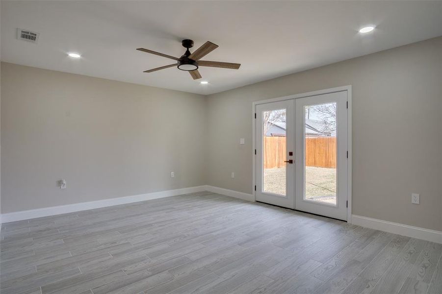 Unfurnished room with visible vents, french doors, light wood-type flooring, and baseboards