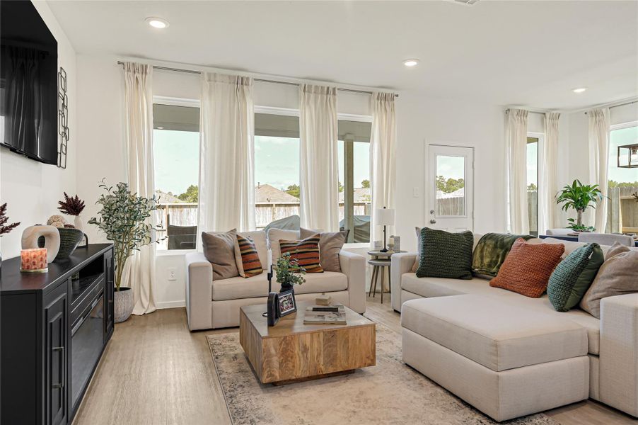 Bright and inviting living room featuring large windows, cozy seating, and a stylish entertainment console, perfect for relaxation and gatherings. Bright and inviting living room featuring large windows, cozy seating, and a stylish entertainment console, perfect for relaxation and gatherings.