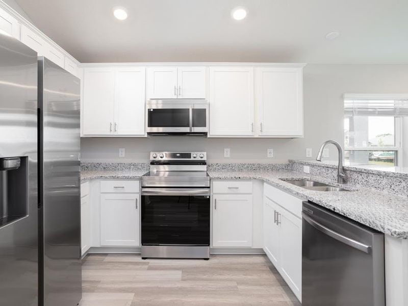 Enjoy an open kitchen with 36in cabinets, Samsung SS appliances, and a walk-in pantry.  Photo showcases a home with similar finishes. Color and design options in actual home for sale may differ.