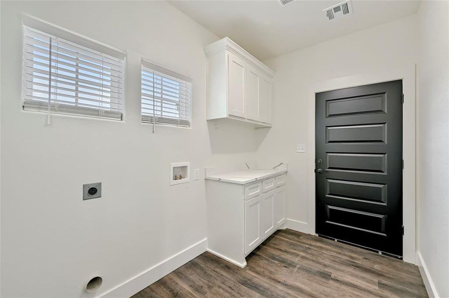 Laundry area featuring cabinet space, dark wood-style flooring, washer hookup, hookup for an electric dryer, and visible vents