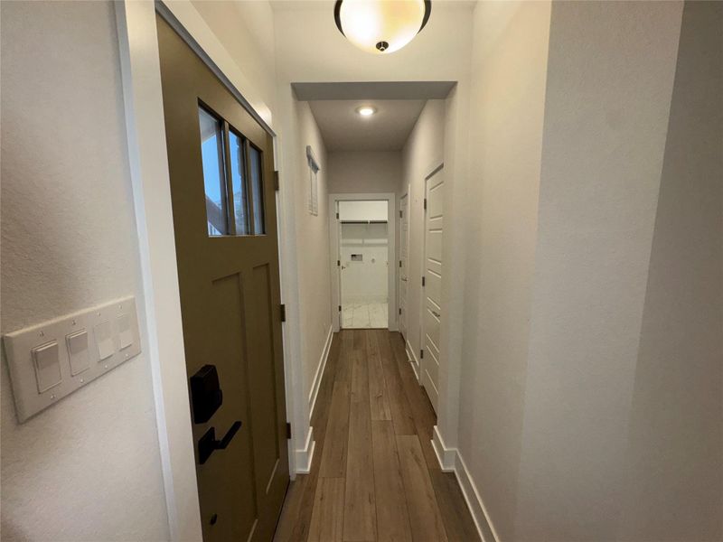Hallway featuring baseboards and finished floors
