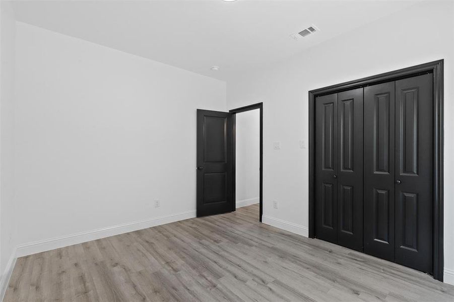 Unfurnished bedroom featuring light wood-type flooring and a closet