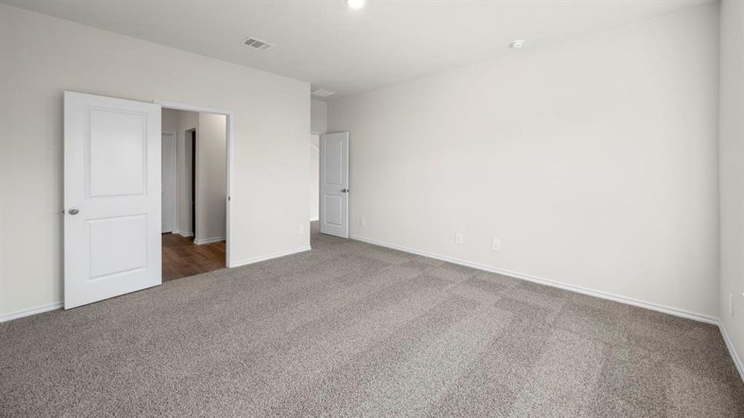 Unfurnished bedroom with carpet flooring and baseboards