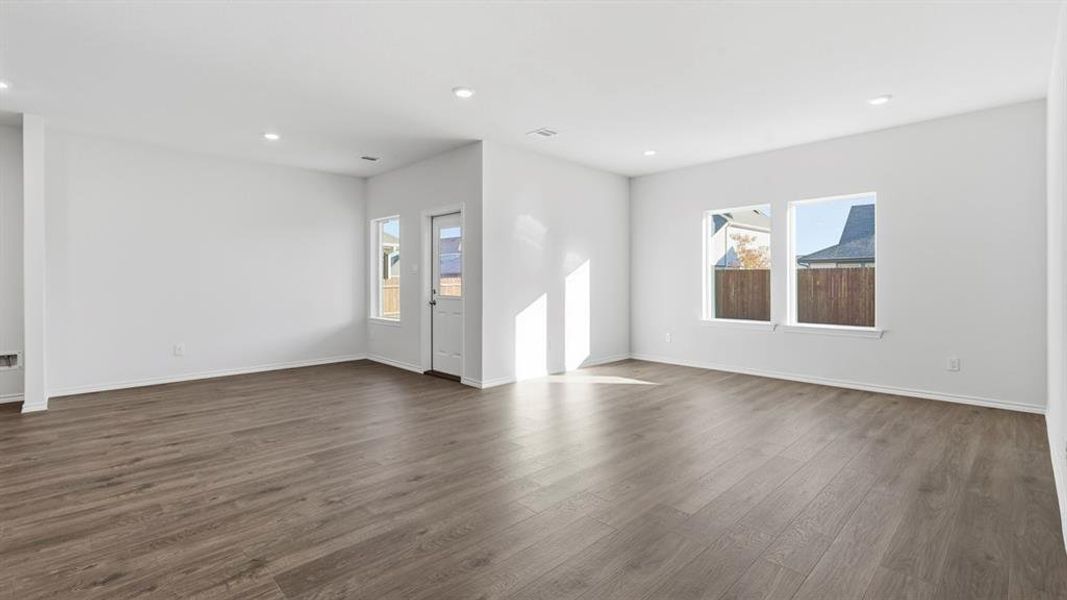 Unfurnished living room with dark wood-style floors and recessed lighting