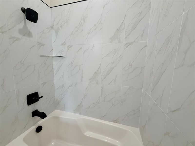 Bathroom featuring washtub / shower combination