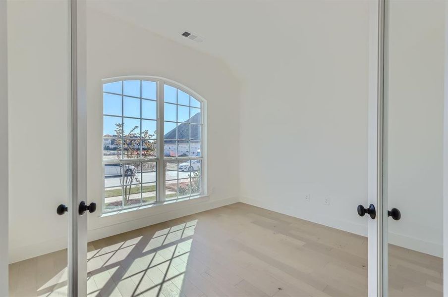 Unfurnished room featuring french doors and light hardwood / wood-style floors