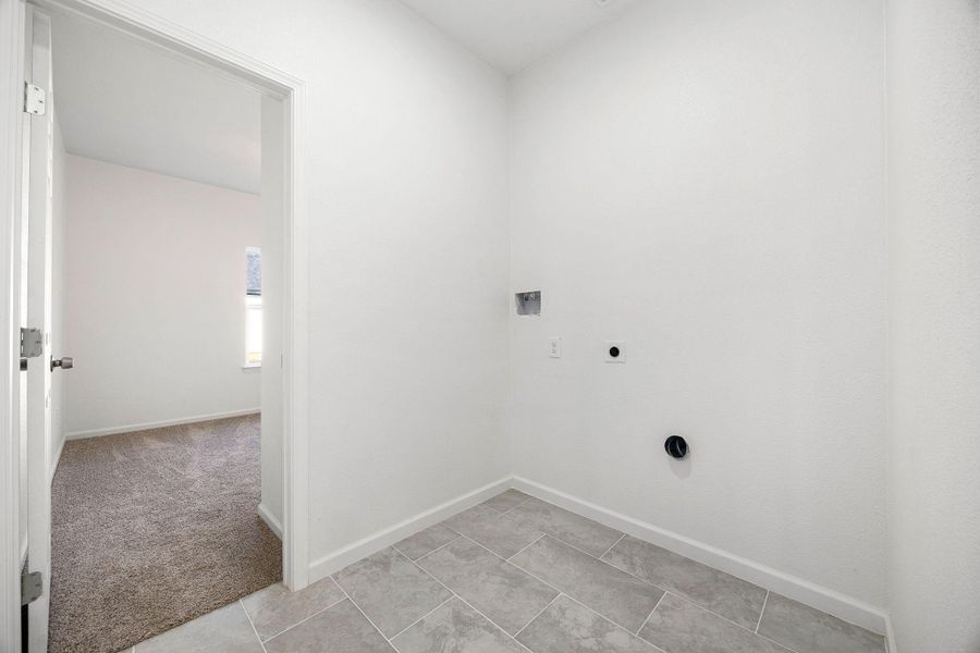 Stylish laundry area with modern tile flooring ready for your appliances. Stylish laundry area with modern tile flooring ready for your appliances.