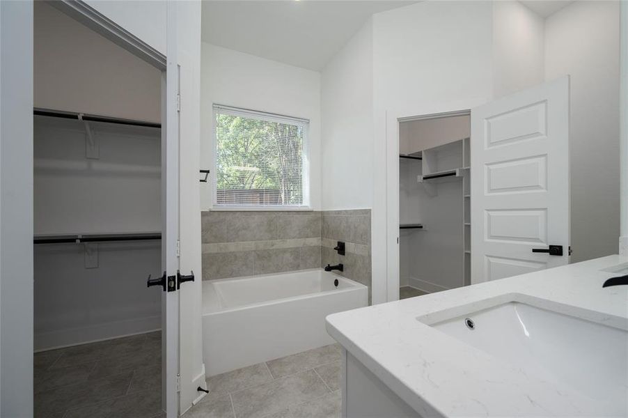 Bathroom with a washtub, vanity, and tile patterned floors