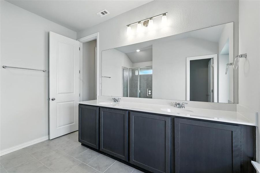 Full bath with double vanity, a stall shower, and tile patterned flooring Full bath with double vanity, a stall shower, and tile patterned flooring