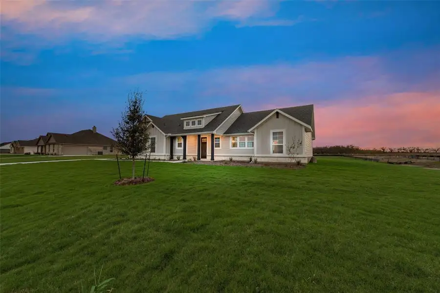 View of front of house featuring a lawn, covered porch, and board and batten siding