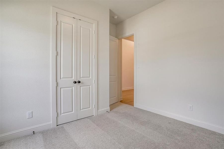 Unfurnished bedroom with a closet and light carpet