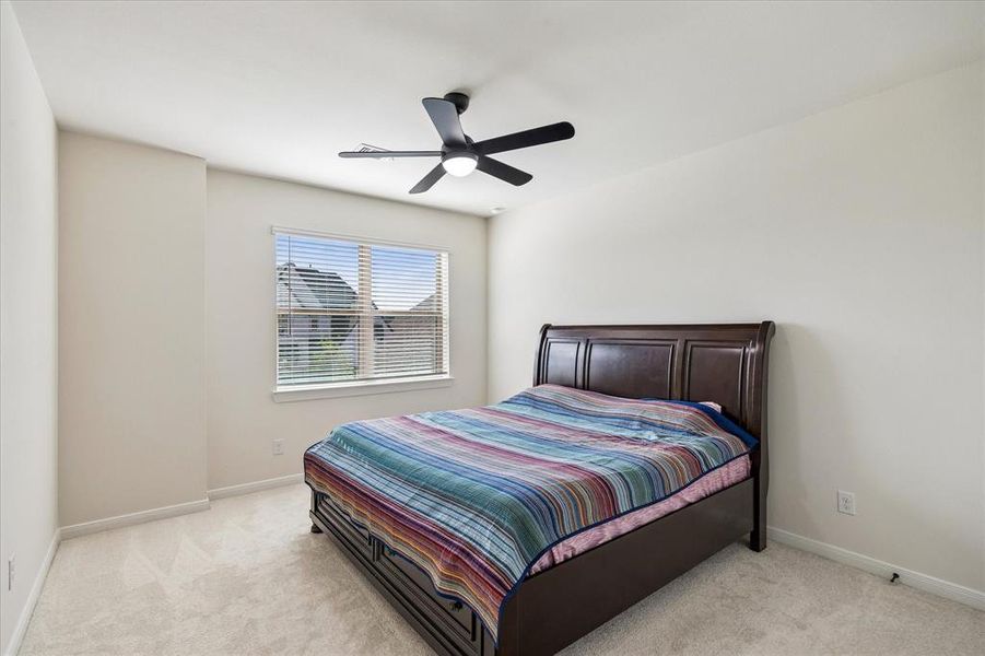 Bedroom featuring neutral-toned walls, white trim, and light-colored carpeting Bedroom featuring neutral-toned walls, white trim, and light-colored carpeting