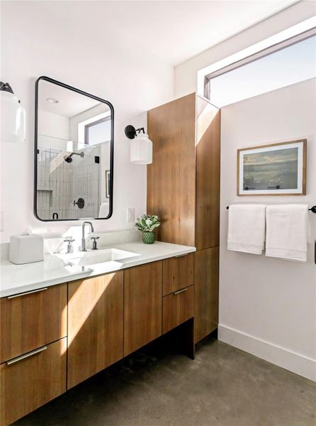 Contemporary bathroom featuring floating-style cabinetry, modern fixtures, and abundant natural light throughout the space. Walk-in glass shower in the mirror. Contemporary bathroom featuring floating-style cabinetry, modern fixtures, and abundant natural light throughout the space. Walk-in glass shower in the mirror.