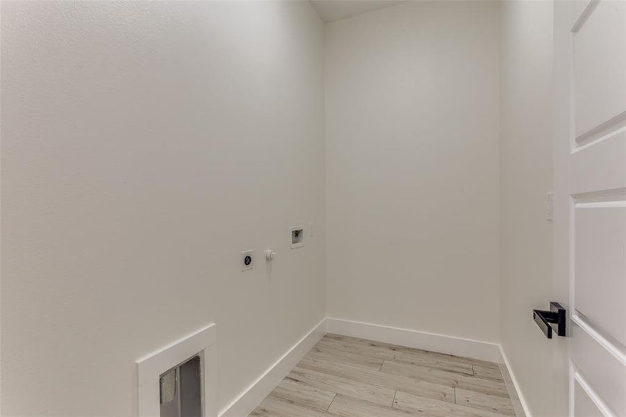 Laundry area with hookup for a washing machine, baseboards, hookup for an electric dryer, laundry area, and light wood-style floors