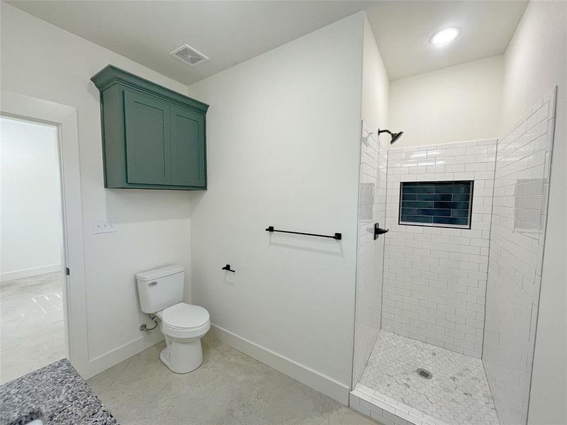 Bathroom with tiled shower and toilet