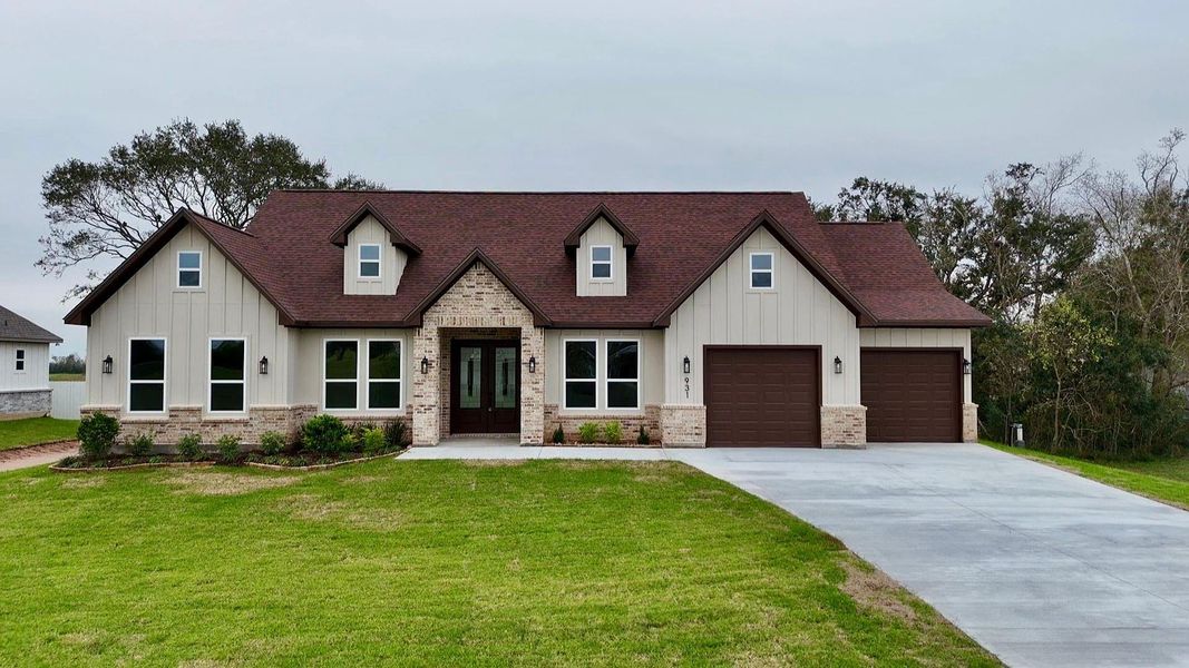 This photo shows a charming house with a rustic design, featuring a red gabled roof and a mix of stone and siding exterior. It has a spacious front yard with a paved driveway leading to an attached two-car garage. Large windows offer plenty of natural light. This photo shows a charming house with a rustic design, featuring a red gabled roof and a mix of stone and siding exterior. It has a spacious front yard with a paved driveway leading to an attached two-car garage. Large windows offer plenty of natural light.
