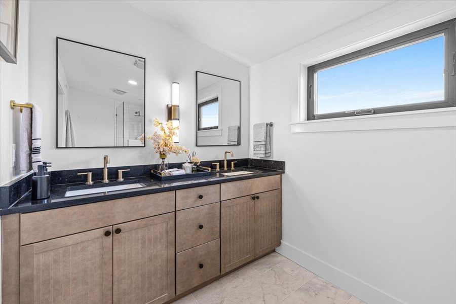 Full bath with a sink, baseboards, marble finish floor, and double vanity