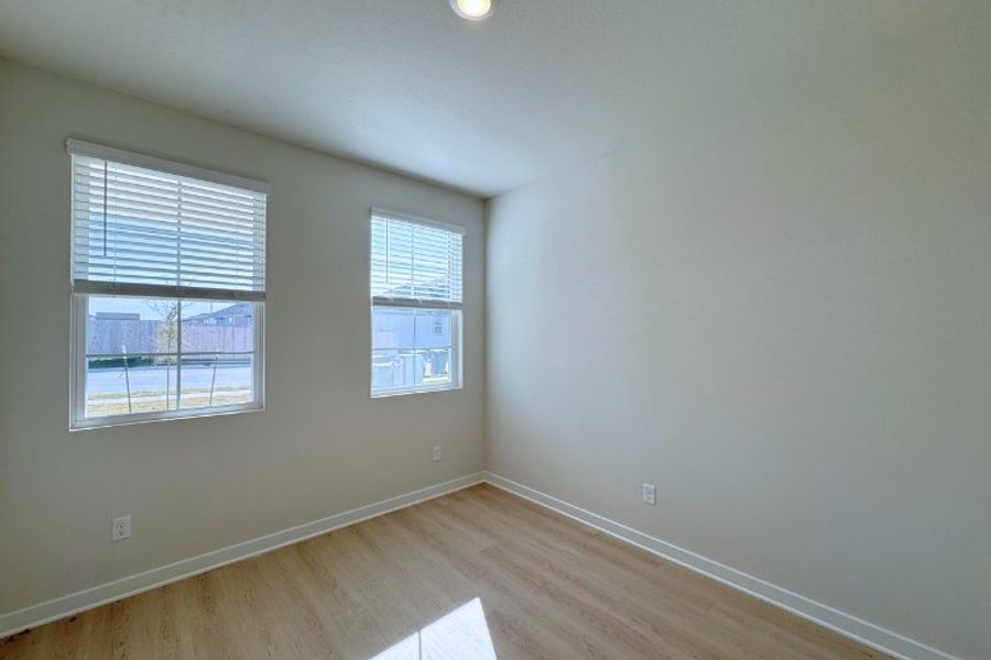 A room with windows and wood floor.