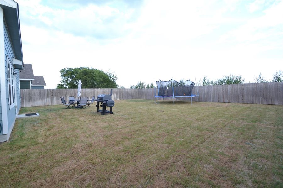 Fenced backyard with a trampoline