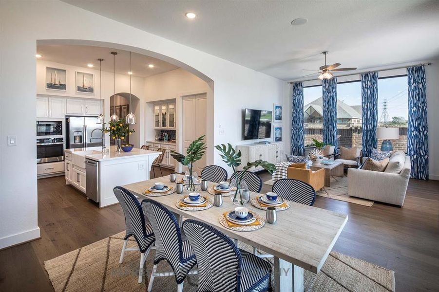 Dining space featuring dark wood finished floors, ceiling fan, arched walkways, and recessed lighting Dining space featuring dark wood finished floors, ceiling fan, arched walkways, and recessed lighting