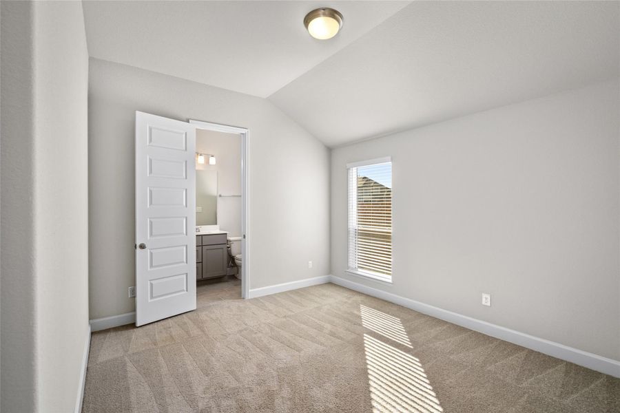 Dedicated Guest Suite bedroom with vaulted ceiling and access to the Private Ensuite Bath.