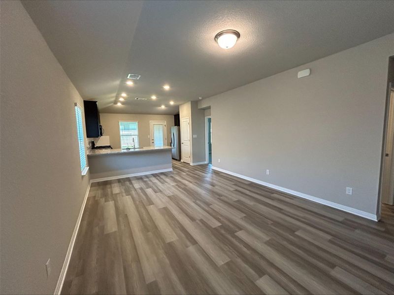 Unfurnished living room with dark wood-style flooring and recessed lighting Unfurnished living room with dark wood-style flooring and recessed lighting
