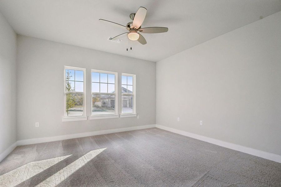Empty room with carpet flooring and a ceiling fan