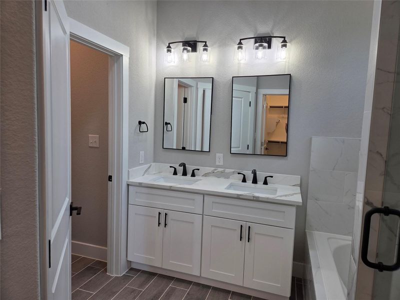 Full bath featuring double vanity, a garden tub, a shower stall. Full bath featuring double vanity, a garden tub, a shower stall.