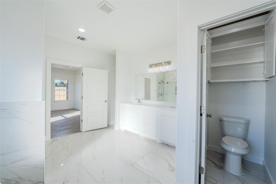 Full bathroom featuring a marble finish shower, double vanity, light marble finish floors, and recessed lighting Full bathroom featuring a marble finish shower, double vanity, light marble finish floors, and recessed lighting
