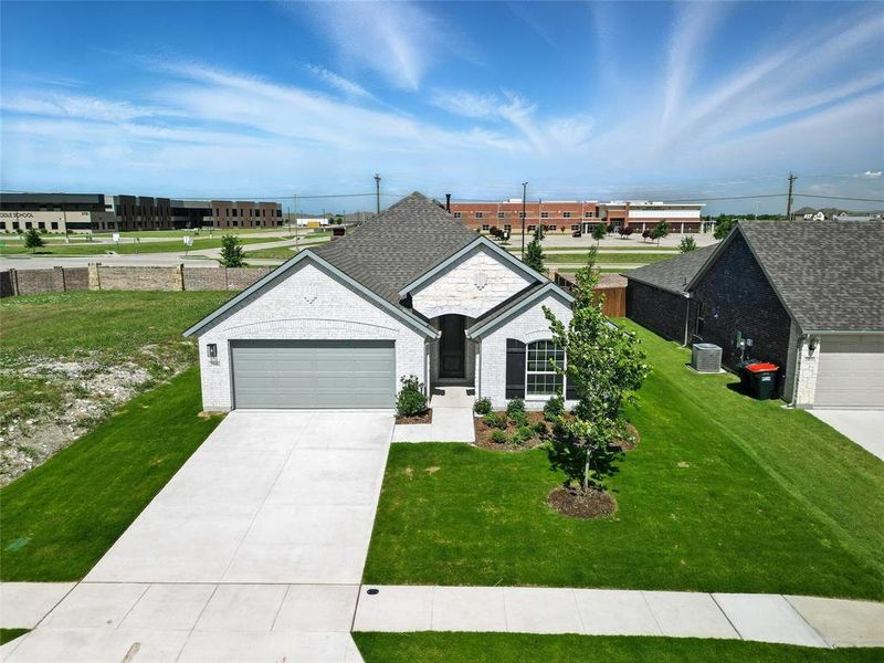 View of front of house with a garage, a front lawn, concrete driveway, and stone siding View of front of house with a garage, a front lawn, concrete driveway, and stone siding