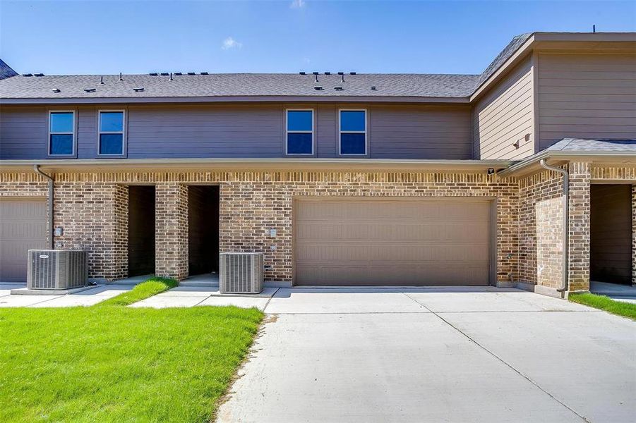 View of front of property with driveway, brick siding, and a garage View of front of property with driveway, brick siding, and a garage
