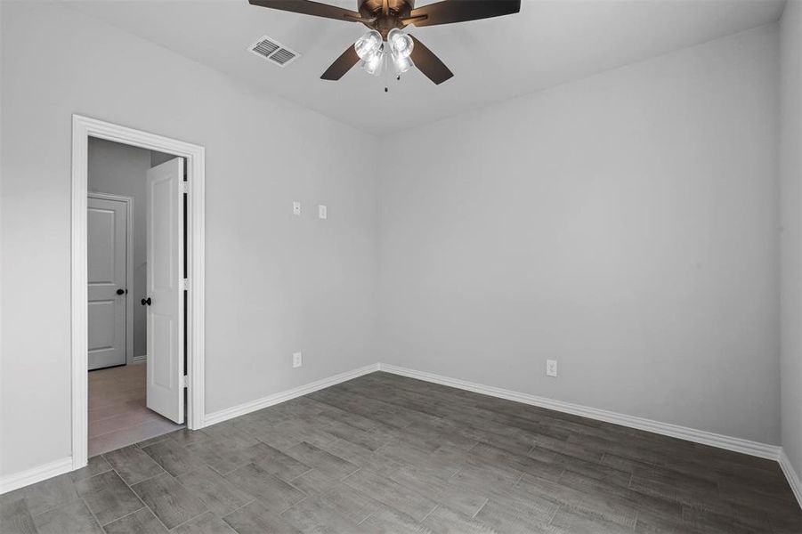 Spare room with hardwood / wood-style flooring and ceiling fan