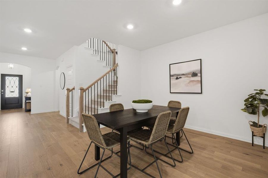 Open dining area with warm wood flooring and seamless flow to the living room and kitchen. Designed for everyday meals, holidays, and entertaining.