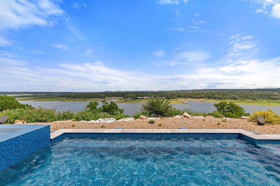 Infinity-edge pool with mosaic tile detailing and integrated spa