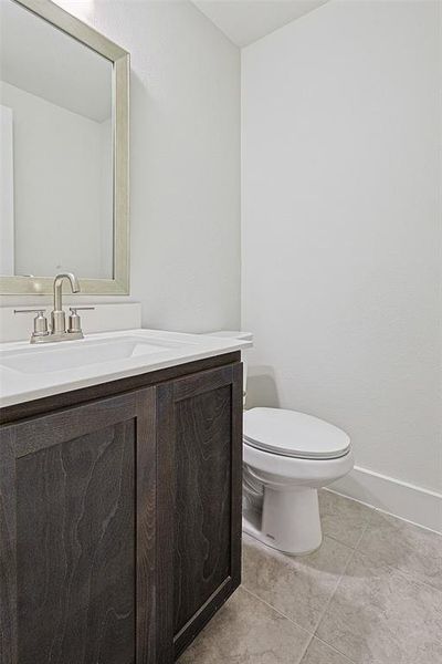 Half bathroom featuring vanity and light tile patterned flooring
