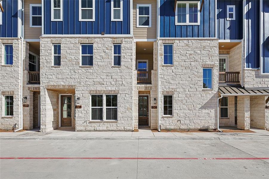 This property features an appealing exterior with light-colored stone facade and blue vertical siding