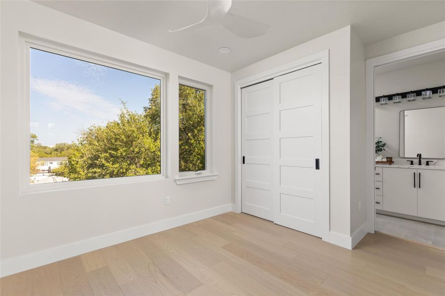 Natural light pours through oversized windows highlighting the clean lines and light hardwood floors.