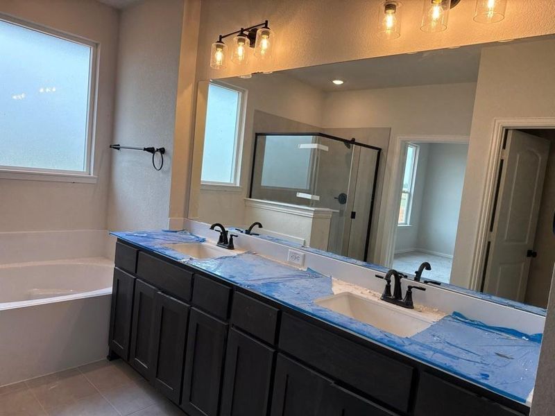 Dual vanity with dark wood cabinetry, integrated sinks, and matte black fixtures