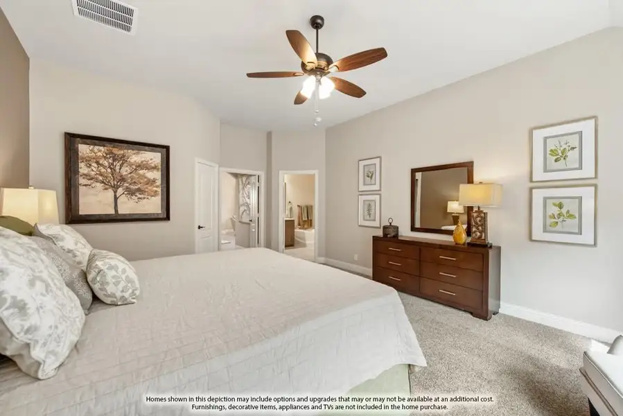 Bedroom with king bed, ceiling fan, wood dresser, and ensuite bathroom doorway visible