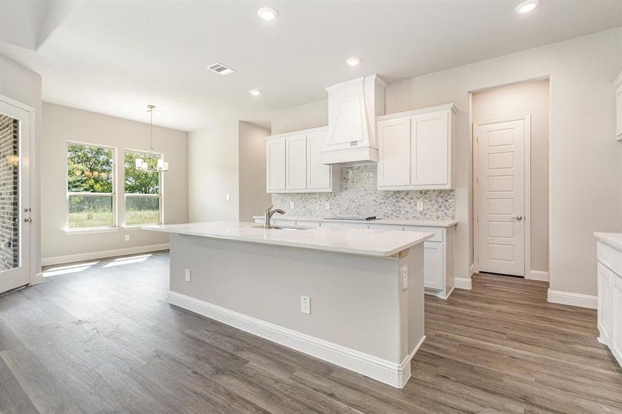 Kitchen with white cabinets, backsplash, hanging light fixtures, premium range hood, and recessed lighting Kitchen with white cabinets, backsplash, hanging light fixtures, premium range hood, and recessed lighting