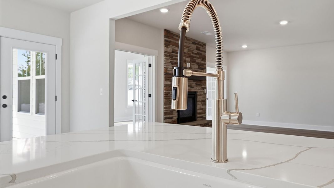 Well-designed kitchen with a center island and tasteful finishes that elevate everyday living by DRB Homes