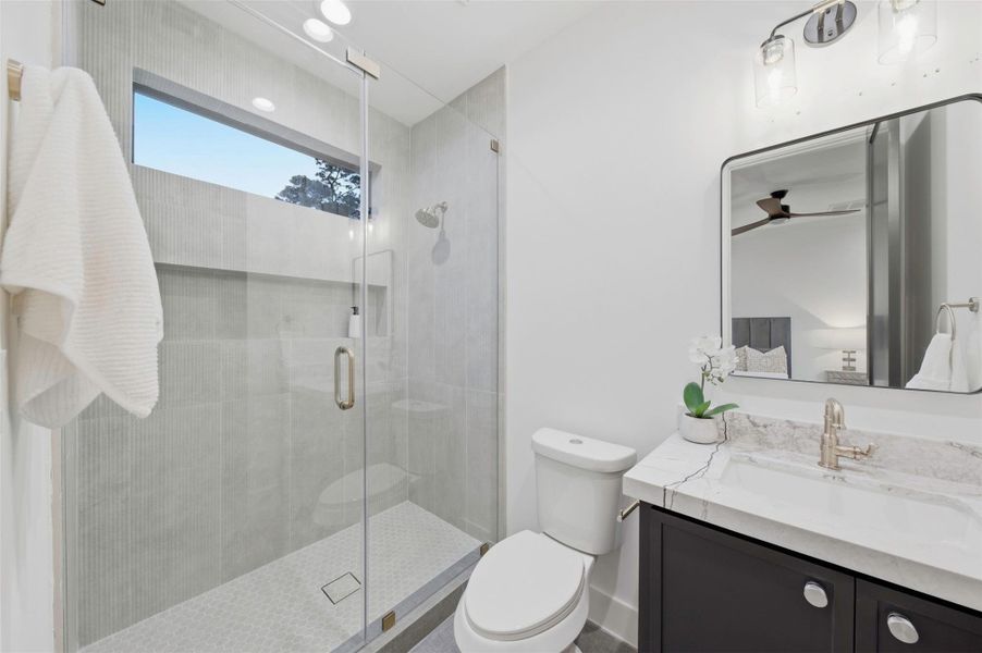 Ensuite secondary bathroom is finished with designer selections and custom cabinetry.