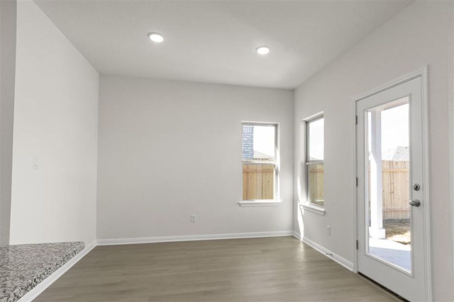 Doorway with baseboards, wood finished floors, and recessed lighting
