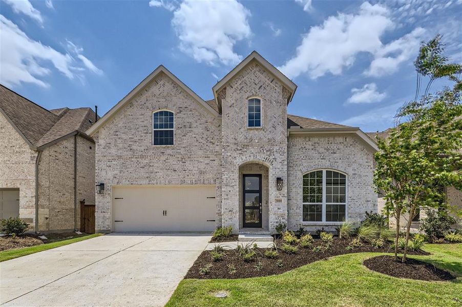 French country home featuring a garage