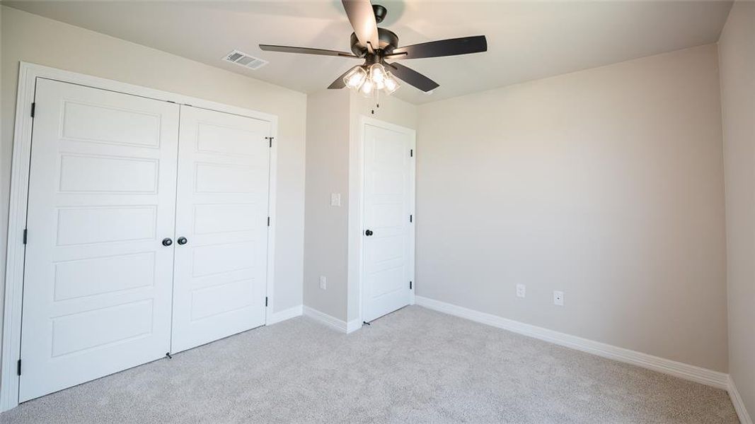 Unfurnished bedroom featuring light colored carpet, a closet, and ceiling fan Unfurnished bedroom featuring light colored carpet, a closet, and ceiling fan