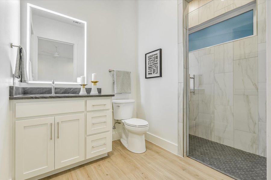 Bathroom with a stall shower, vanity, and light wood-style floors