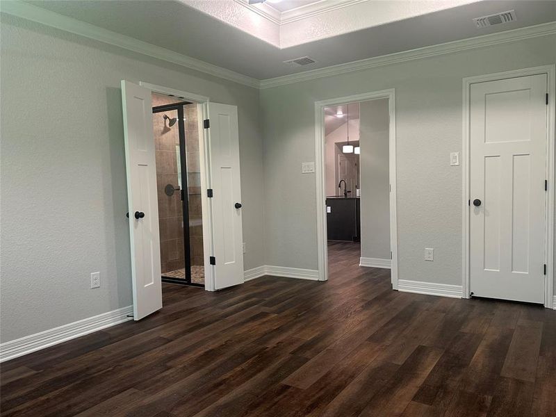 Unfurnished bedroom with dark wood finished floors and crown molding