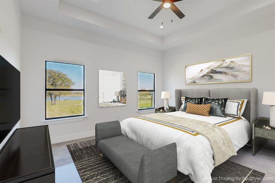 Bedroom with multiple windows, ceiling fan, and a raised ceiling